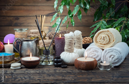 Spa treatment with candles and towel on wooden table, closeup