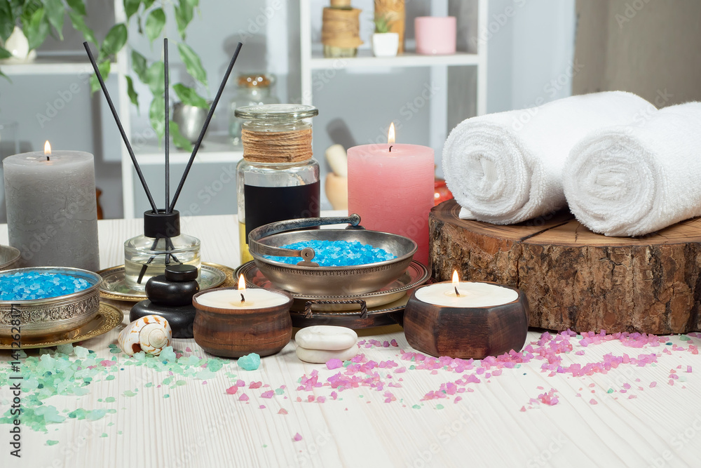 Spa treatment with candles and towel on wooden table, closeup