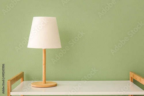 table lamp on white shelf near green wall