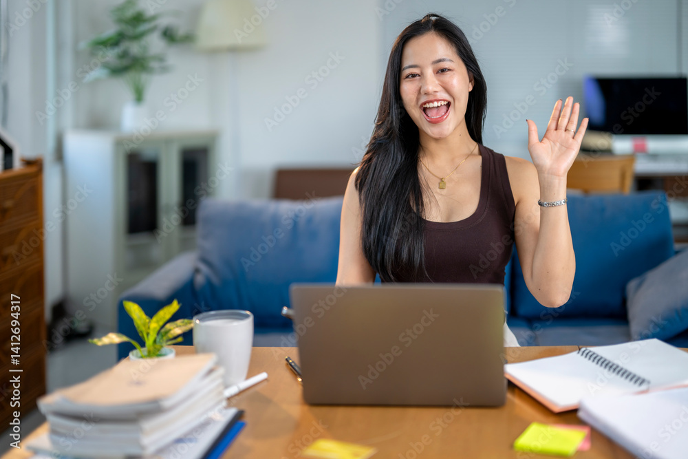 A woman is sitting at a desk with a laptop and a stack of books A woman is sitting at a desk with a laptop and a stack of books