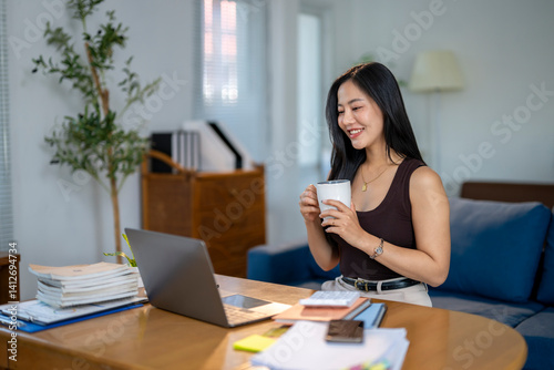 A woman is sitting at a desk with a laptop and a cup of coffee Free Download A woman is sitting at a desk with a laptop and a cup of coffee - GFXLoad