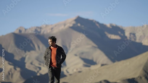 4K footage of Indian man walking slowly on a high-altitude ridge in Ladakh, Lamayuru moonland of India, gazing at the view.