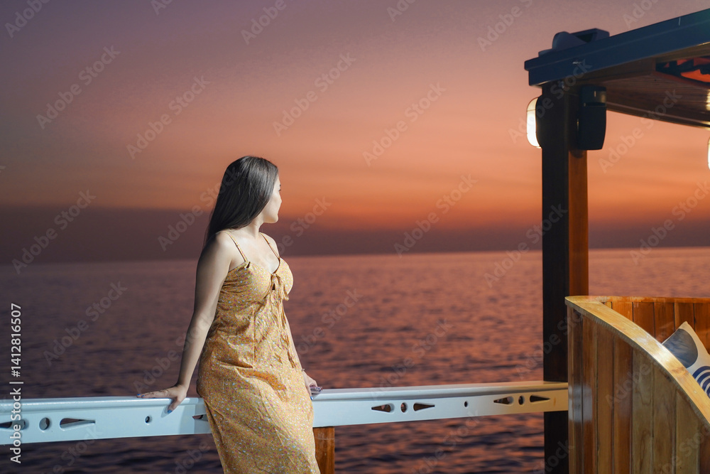 woman in summer dress gazes at serene ocean sunset from boat deck, creating peaceful and contemplative scene