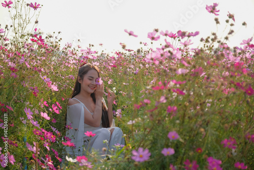 Obraz na płótnie woman in white dress sits joyfully among vibrant pink and white flowers in sunlit field w salonie