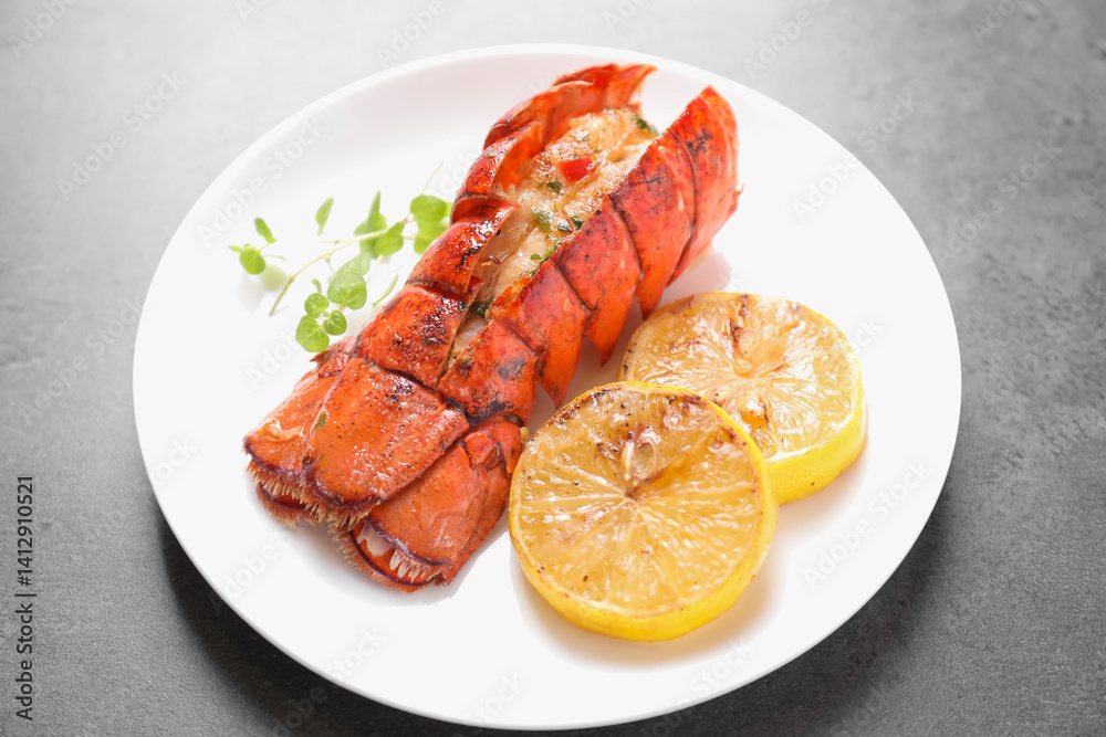 Delicious lobster tail with microgreens and slices of lemon on grey textured table, closeup Delicious lobster tail with microgreens and slices of lemon on grey textured table, closeup