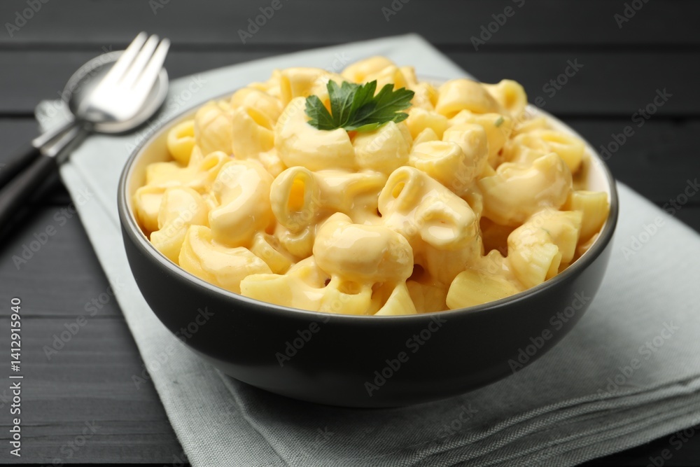 Delicious macaroni and cheese with parsley served on black wooden table, closeup Delicious macaroni and cheese with parsley served on black wooden table, closeup