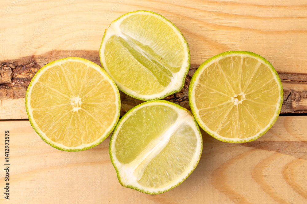 Cut juicy limes on a wooden table, close-up, top view. Cut juicy limes on a wooden table, close-up, top view.