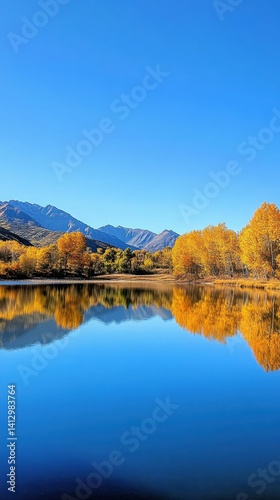Autumn trees reflected in calm lake, mountains.