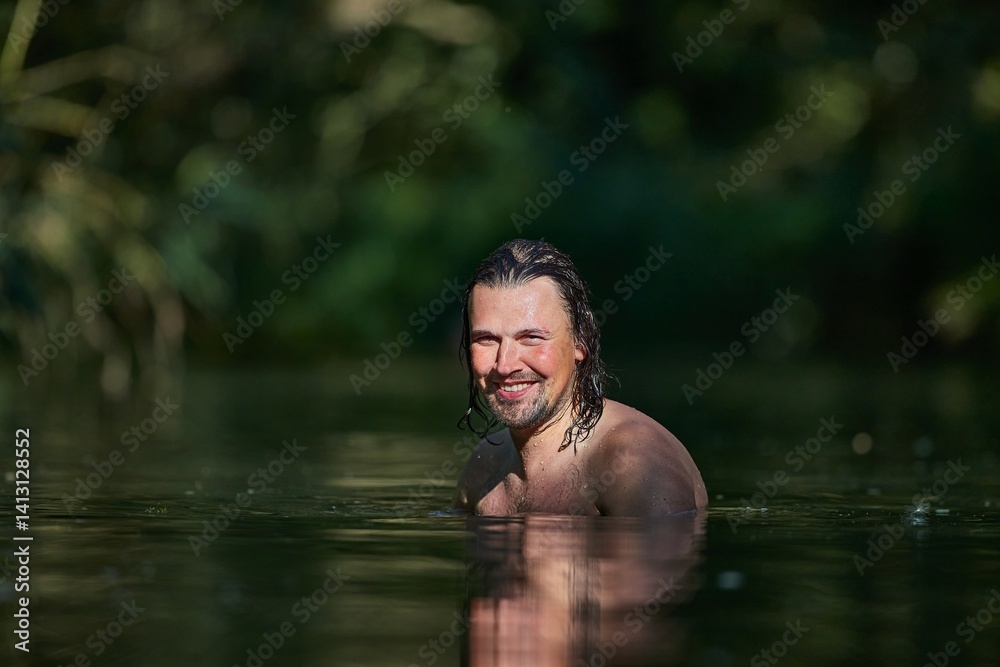 Man swimming in a small river in summer