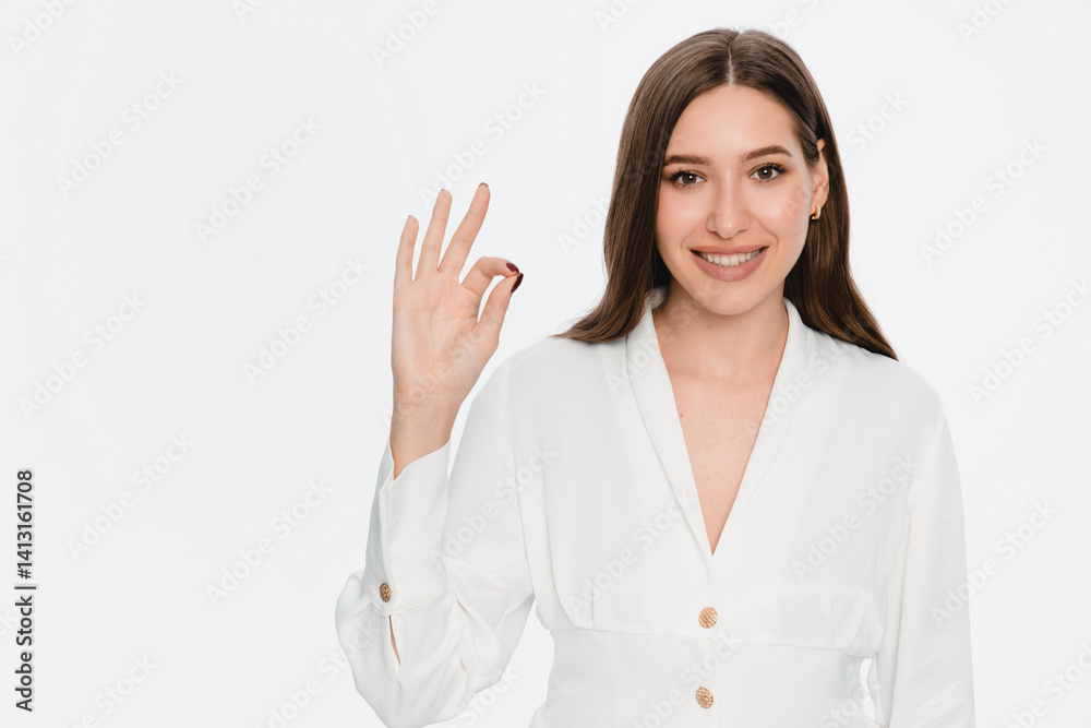 Photo of smiling young woman lady girl female manager in casual clothes outfit standing showing Ok okay gesture sign symbol looking camera isolated on white light color background studio portrait Photo of smiling young woman lady girl female manager in casual clothes outfit standing showing Ok okay gesture sign symbol looking camera isolated on white light color background studio portrait