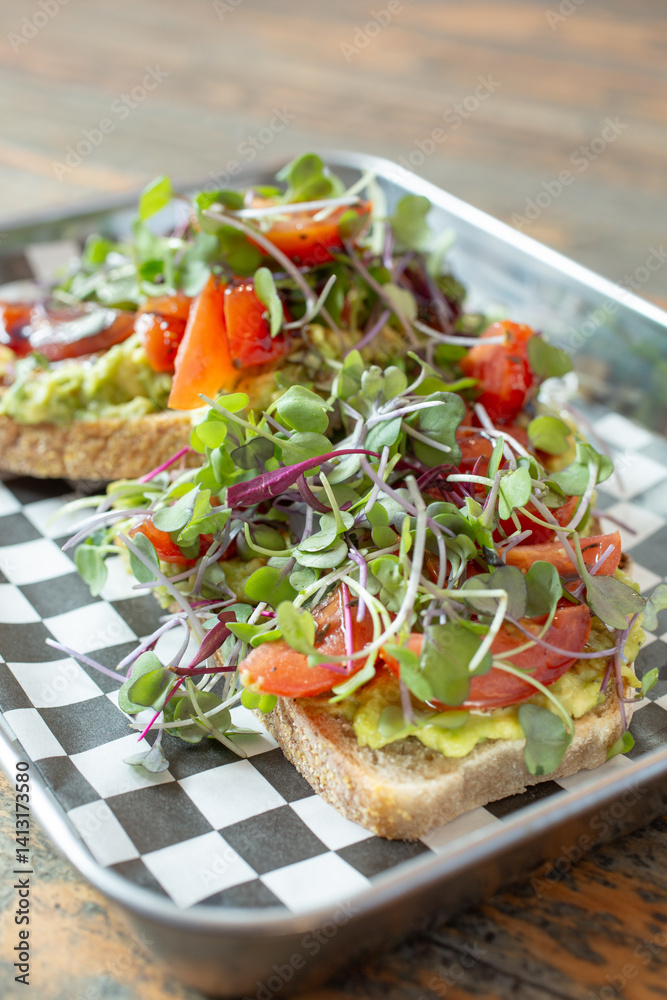 A closeup view of avocado toast, on a metal tray. A closeup view of avocado toast, on a metal tray.