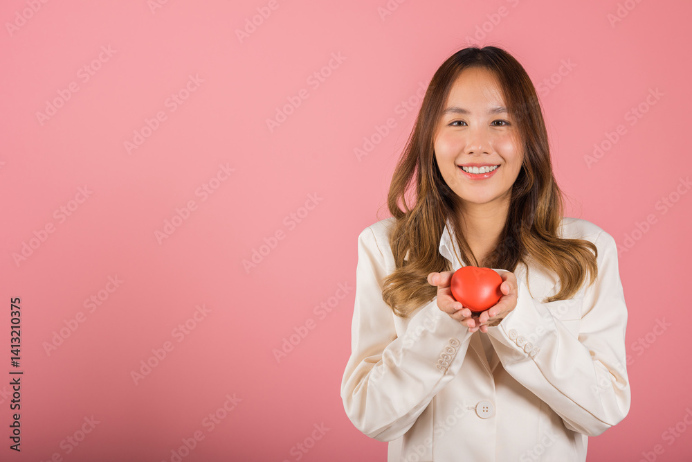 Smiling woman confidence showing holding red heart with her hand palm isolated pink background, Asian happy portrait beautiful young female send love and happy valentine in studio shot, copy space Smiling woman confidence showing holding red heart with her hand palm isolated pink background, Asian happy portrait beautiful young female send love and happy valentine in studio shot, copy space