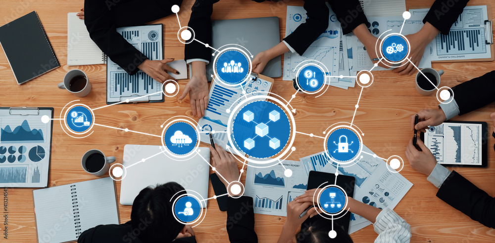 A dynamic business meeting showcasing collaboration over data charts and technology symbols, highlighting teamwork and strategic planning in a professional environment. Amity