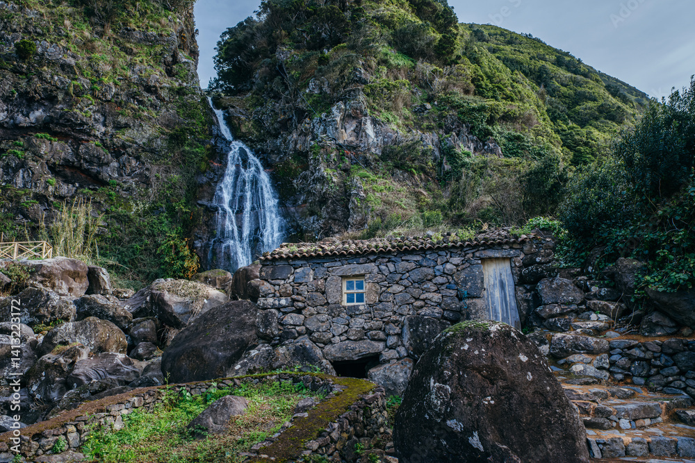 Enchanting Stone House by Cascading Waterfall: Historic Ruin at Sao Jorge, Azores, Portugal. Rustic Charm Amidst Natural Beauty and Lush Landscape