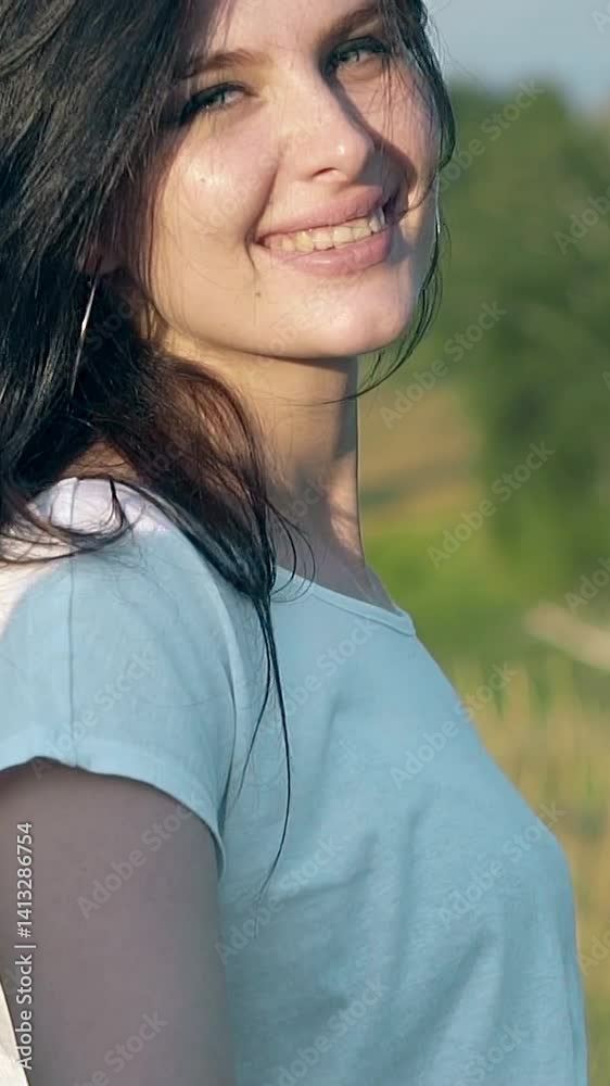 close view smiling brunette girl in white t-shirt walks on green meadow holding man hand on foreground slow motion close view smiling brunette girl in white t-shirt walks on green meadow holding man hand on foreground slow motion