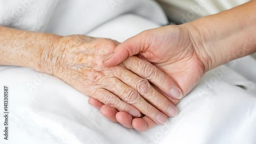 A touching moment where a youthful hand offers support and love to a wrinkled, elderly hand.