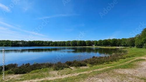 Picturesque natural swimming lake pond Spokeplas near Noordwolde in the Netherlands. An idyllic recreational lake surrounded by a lush nature forest.