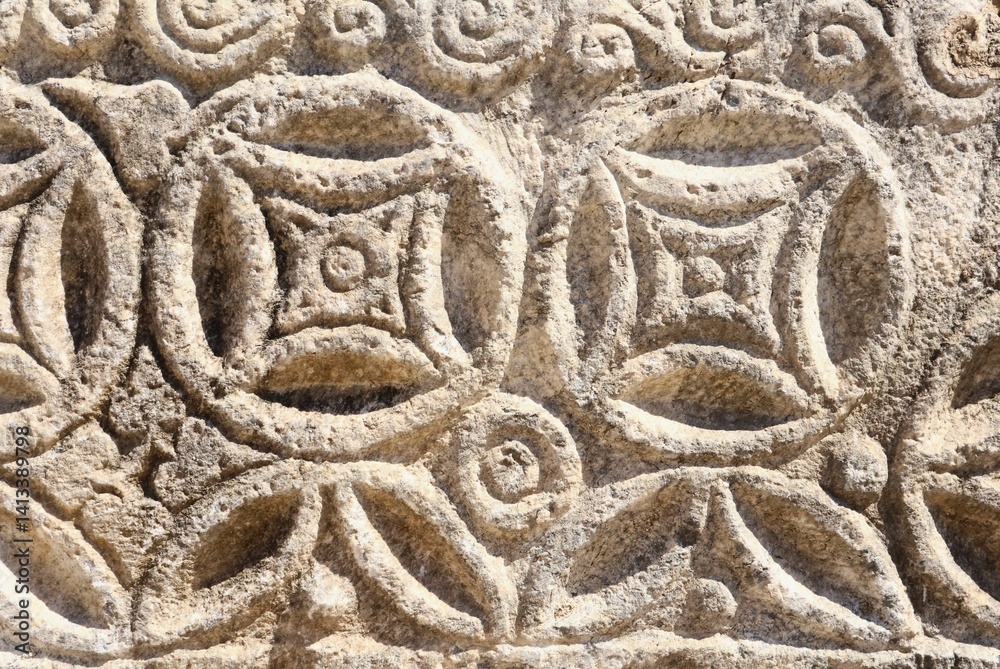 Stone carving border section in ancient city ruins. Ancient art textured background. Stone carving texture. Background for designs.Ancient stone carving, geometric and floral patterns. In Bodrum. Stone carving border section in ancient city ruins. Ancient art textured background. Stone carving texture. Background for designs.Ancient stone carving, geometric and floral patterns. In Bodrum.