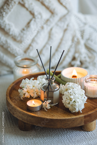 Cozy corner for home meditation and relaxation. Decor for apartment, house, indoors design. Aroma diffuser, burning scented candles, spring aromatherapy with blooming hyacinth floral scent