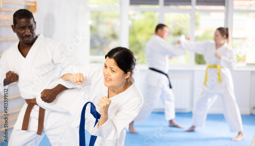 Wallpaper Mural Sportive middle-aged woman trainee of karate courses applying attack methods on her partner Torontodigital.ca