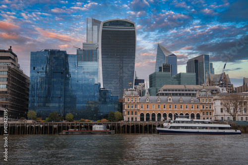 Obraz na płótnie View of London's skyline featuring the Walkie Talkie and Scalpel buildings, the River Thames, a docked boat, and a historic building in the foreground. w salonie