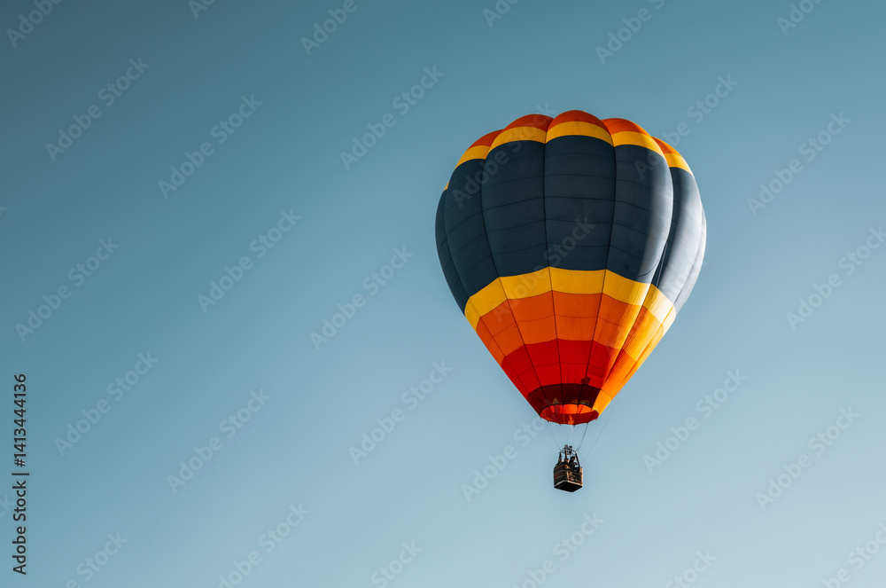 Fototapeta premium Balão de Ar Quente com Cores Vibrantes Voando em Céu Azul