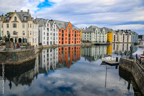 Alesund, Norway. Canal with colorful painted houses, boats, marina, sailor statue. photo