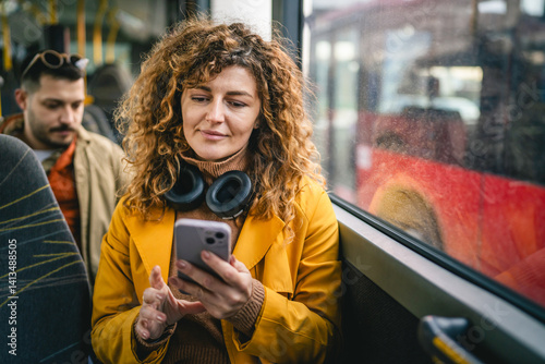 Cuadro en lienzo young adult woman use public transport, sit with phone and headphones
