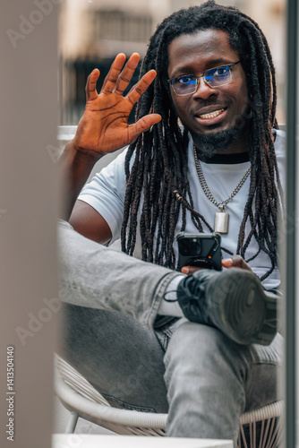 Obraz na płótnie young african man waving with cell phone w salonie