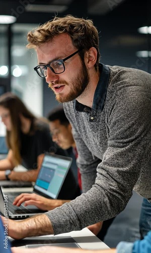 Group of young professionals collaborating on laptops in a modern office setting