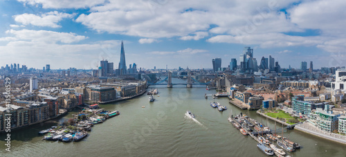 Obraz na płótnie Aerial view of London featuring Tower Bridge over the River Thames, The Shard, Canary Wharf, and historic and modern riverside architecture on a bright day. w salonie