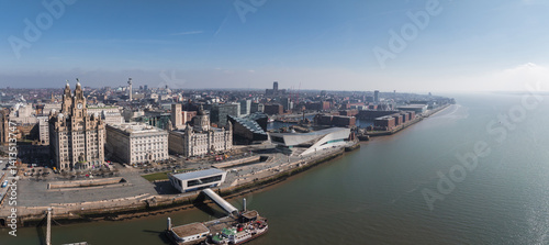 Obraz na płótnie Aerial view of Liverpool showcasing the Royal Liver Building, Cunard Building, Port of Liverpool Building, Museum of Liverpool, and the Mersey River. w salonie