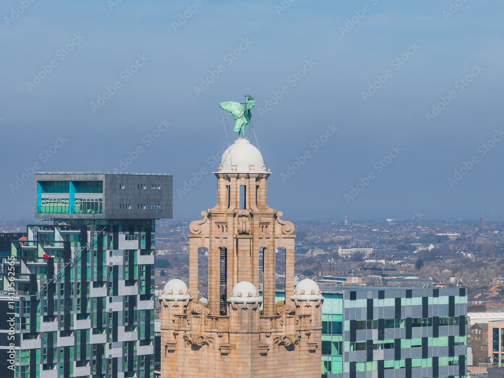Aerial view of Liverpool highlighting the Royal Liver Building with its iconic Liver Bird statue, surrounded by modern and historic architecture under a clear sky.