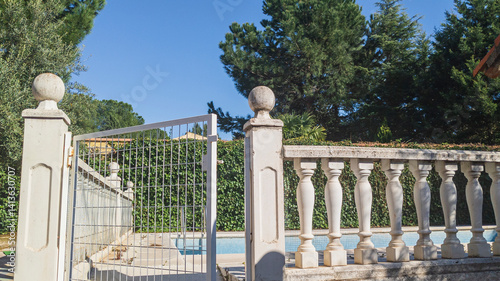 Roman columns railing for pool fence with net. Empty dry swimming pool. Cement column, thick model, European style villa. Colonial style picket concrete fence