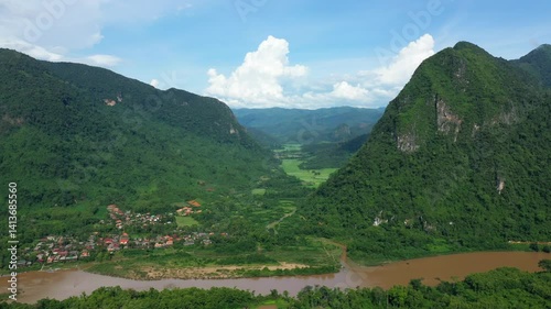 Muang Ngoi Neua nestled between Nam Ou and karst peaks in Asia, Laos, near Luang Prabang, in summer, on a sunny day.  photo
