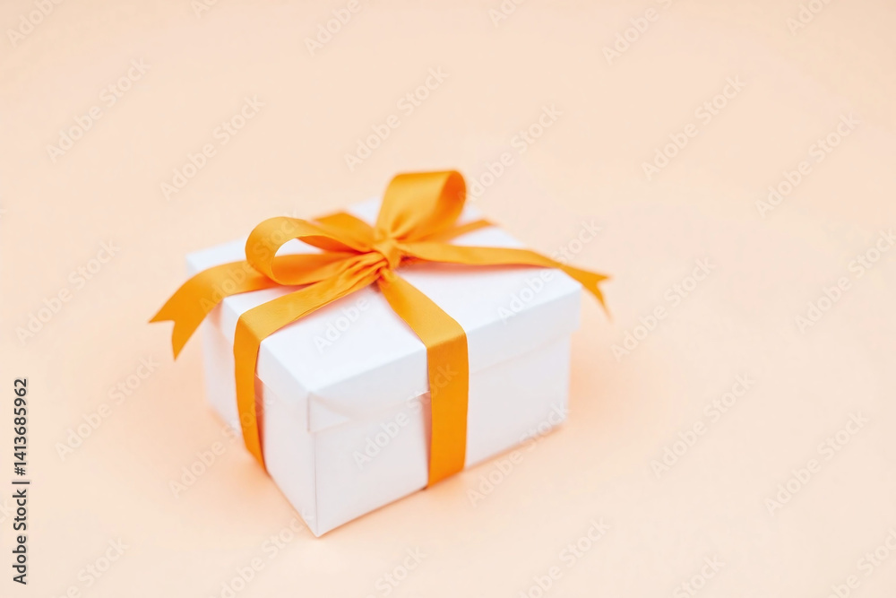 Obraz premium white gift box with an orange ribbon tied around it