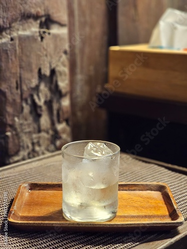 Still life with glass of water, ice and wooden tray