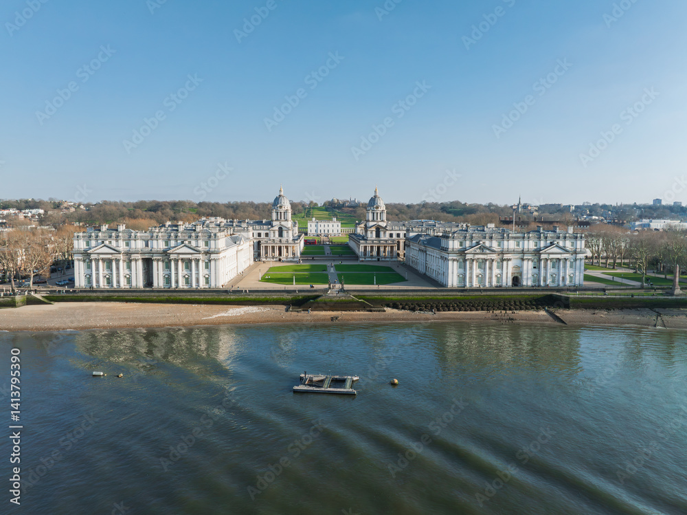 Aerial view of the Old Royal Naval College in Greenwich, London, with twin domed buildings, Thames River, green lawns, and pathways leading to Queen's House.
