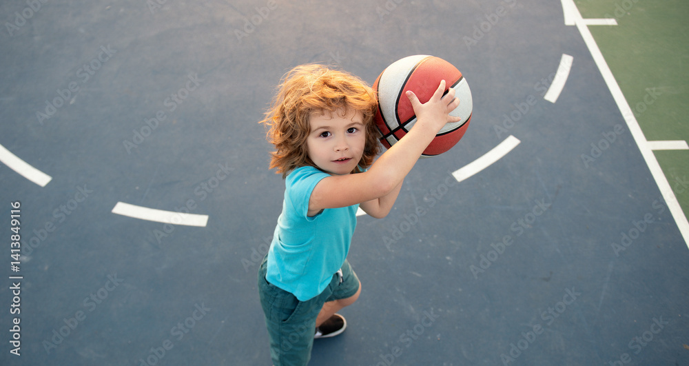 Kid with basketball ball. Cute smiling boy plays basketball. Active kids play basketball, Top view. Sport for kids. Child learn how to play basketball.
