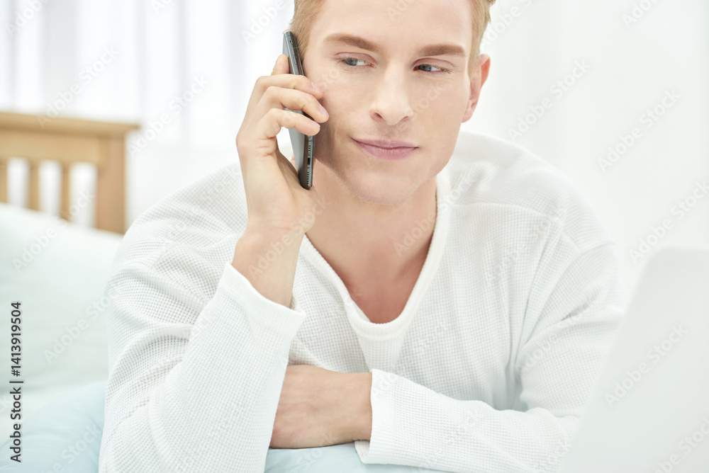 Young Man Working Remotely from Home on Phone and Laptop Young Man Working Remotely from Home on Phone and Laptop