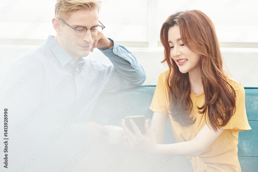 Multinational Man and Woman Having Conversation Indoors with Smartphone and Laptop Multinational Man and Woman Having Conversation Indoors with Smartphone and Laptop