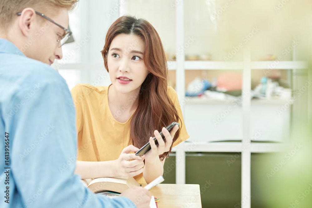 Asian Woman and Man Using Smartphone Together Indoors Asian Woman and Man Using Smartphone Together Indoors