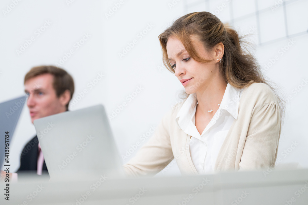Focused professionals collaborating in a modern office setting with laptops and teamwork dynamics Focused professionals collaborating in a modern office setting with laptops and teamwork dynamics