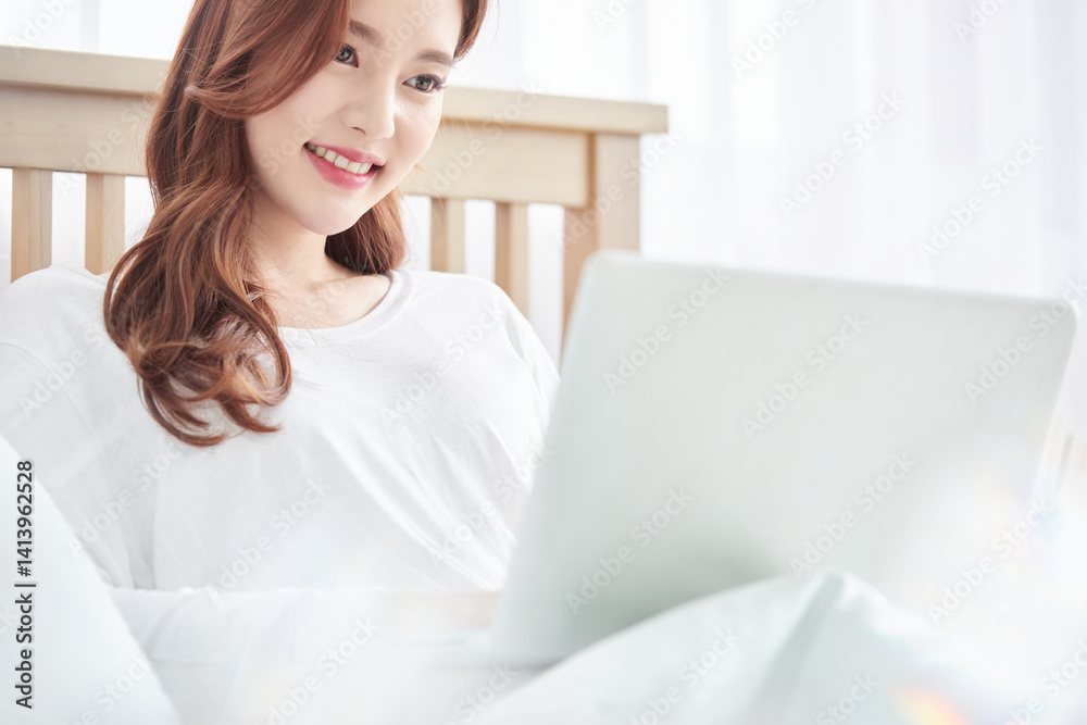 Young Woman Using Laptop in Bed, Bright Morning Lifestyle Young Woman Using Laptop in Bed, Bright Morning Lifestyle