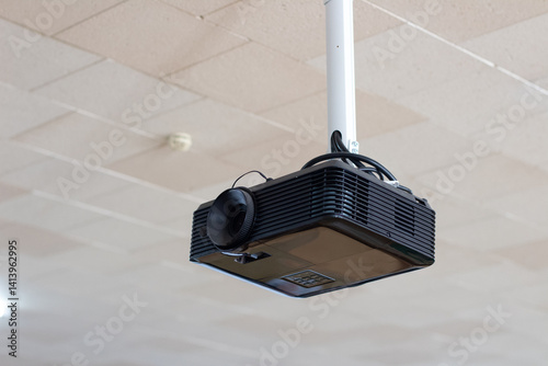 A projector hanging from the ceiling in a room photo