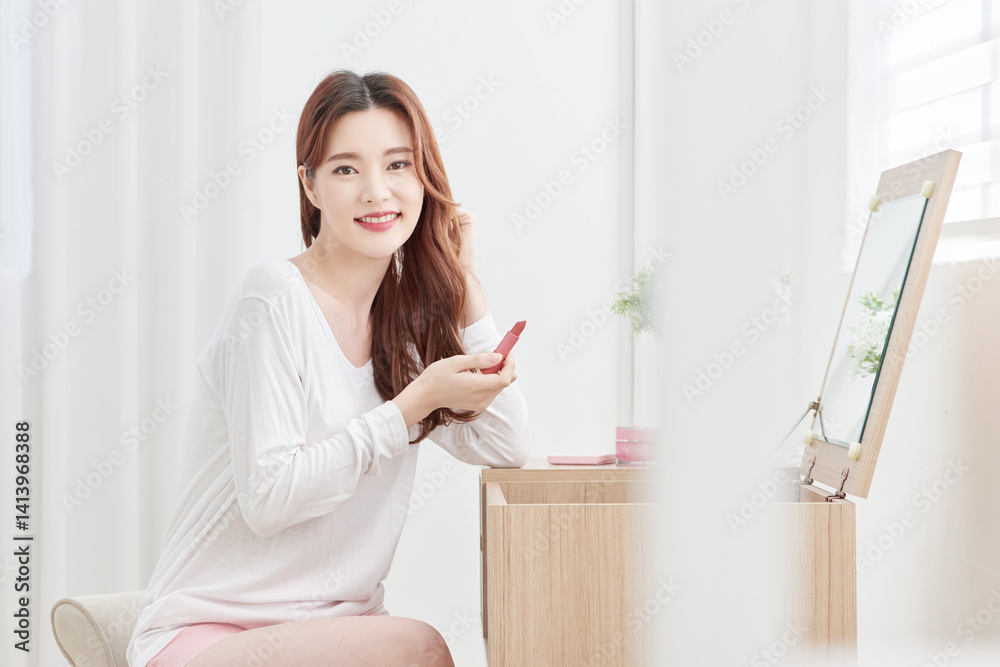 Asian Woman Applying Lipstick at Vanity Table Asian Woman Applying Lipstick at Vanity Table