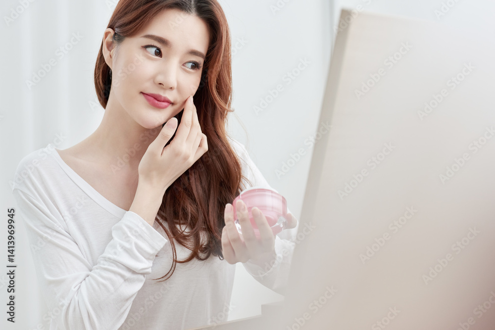 Asian Woman Applying Skincare Product with Pink Container Asian Woman Applying Skincare Product with Pink Container