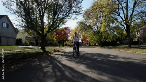 Wallpaper Mural Front wide footage of a woman riding a bicycle fast on the street surrounded by colorful fall foliage enjoying a sunny weather. Torontodigital.ca