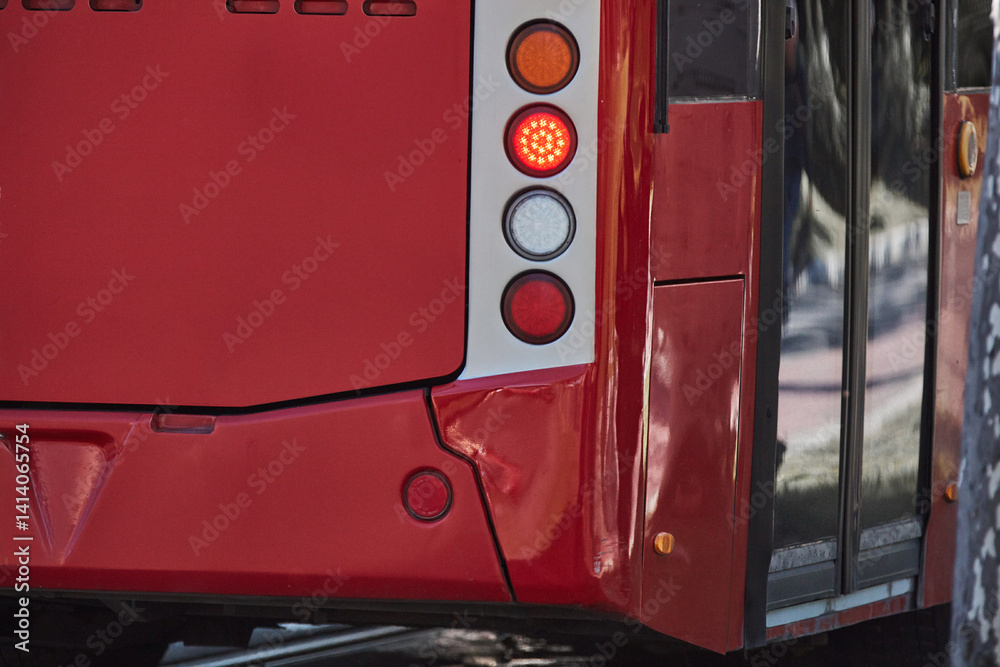 Red bus for public transportation on city streets.