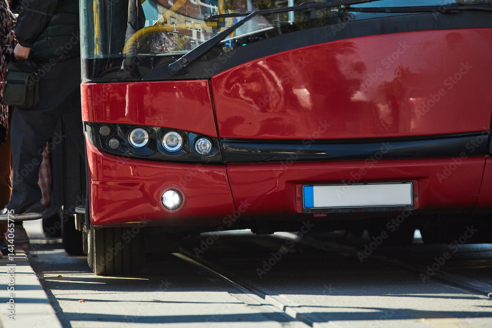 Red bus for public transportation on city streets.